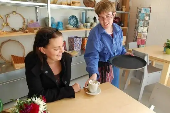 Medewerkers serveert koffie aan gast